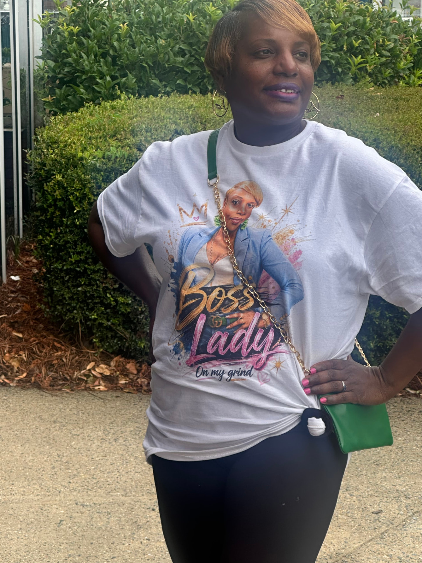TruthWear Customer 001 wearing her one-of-one "Boss Lady — On My Grind" tee, featuring her own airbrush-poster portrait with a crown and gold script